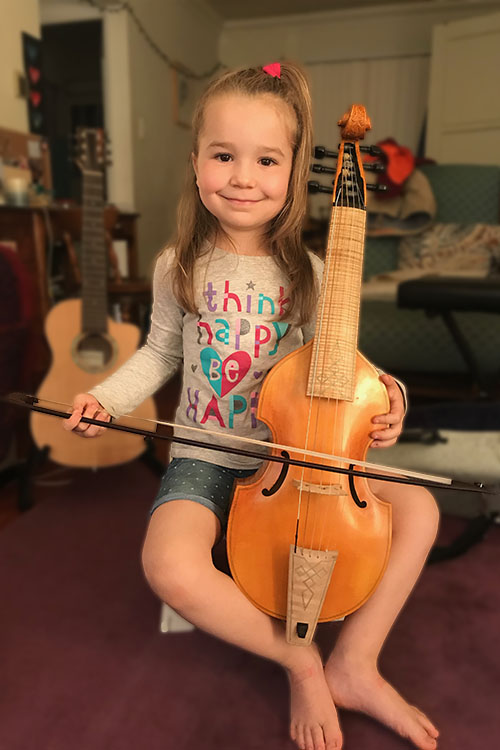 Cours de musique d'un enfant apprenant à jouer de la viole de gambe